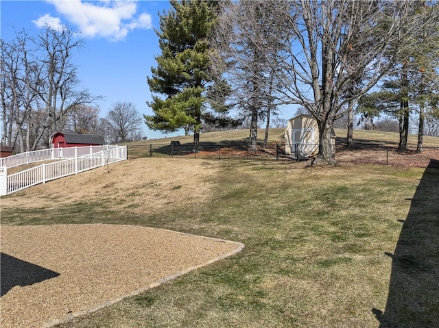 view of yard featuring a shed, a rural view, an outdoor structure, and fence