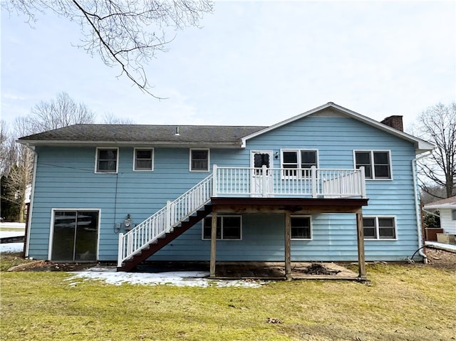 back of property featuring a deck, a lawn, a chimney, and stairs