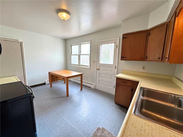 kitchen with brown cabinetry, light countertops, a sink, and tile patterned floors