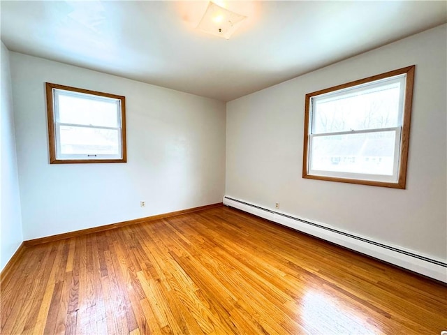 empty room with light wood-style floors, baseboards, and baseboard heating