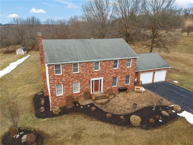 view of front of home with a garage, brick siding, driveway, roof with shingles, and a chimney