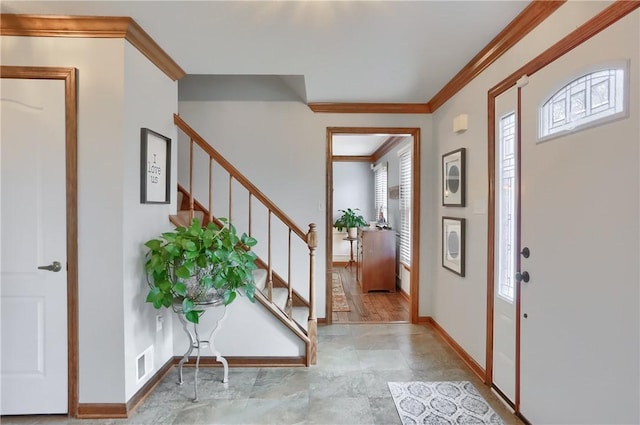 foyer featuring stairway, baseboards, visible vents, and ornamental molding