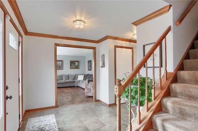 entryway with ornamental molding, stairway, and baseboards