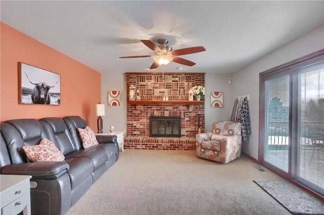 carpeted living room featuring a brick fireplace, visible vents, and a ceiling fan