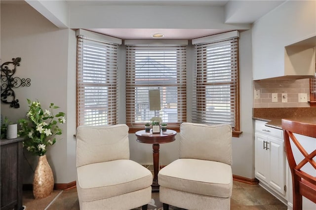 sitting room featuring plenty of natural light and baseboards