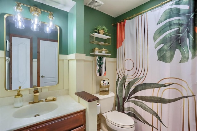 bathroom featuring toilet, a shower with curtain, visible vents, and vanity