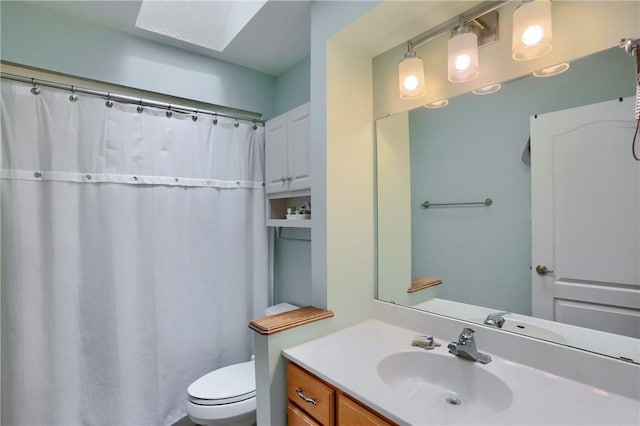 bathroom featuring a skylight, curtained shower, vanity, and toilet