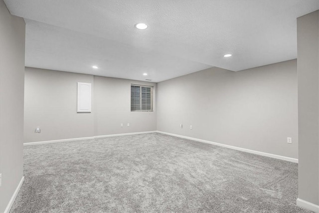 carpeted empty room with a textured ceiling, recessed lighting, and baseboards