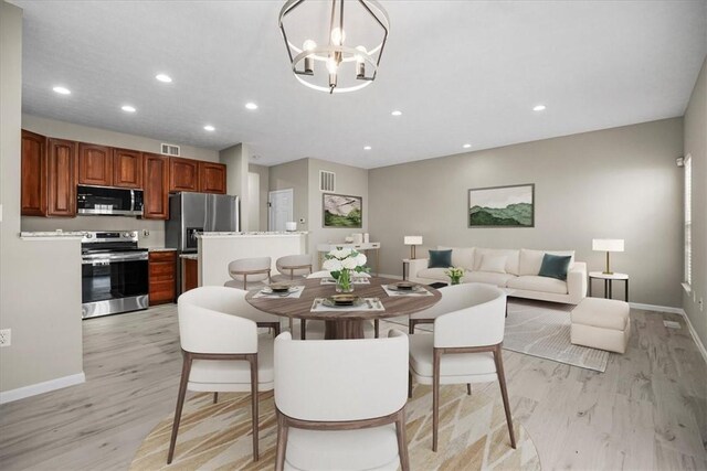 dining space with recessed lighting, visible vents, a notable chandelier, and light wood finished floors