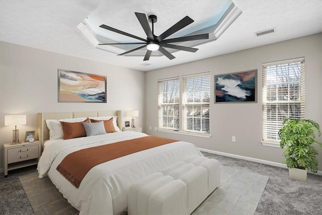 bedroom with visible vents, a raised ceiling, a textured ceiling, and carpet flooring