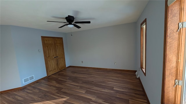 unfurnished bedroom featuring dark wood-style flooring, visible vents, ceiling fan, and baseboards