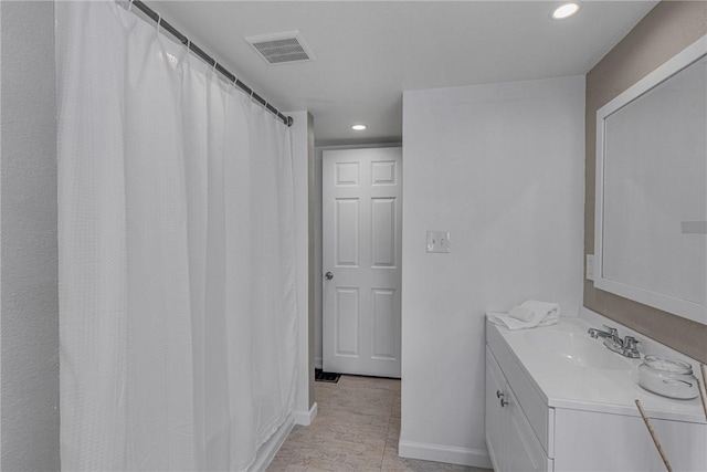 bathroom featuring baseboards, vanity, visible vents, and recessed lighting