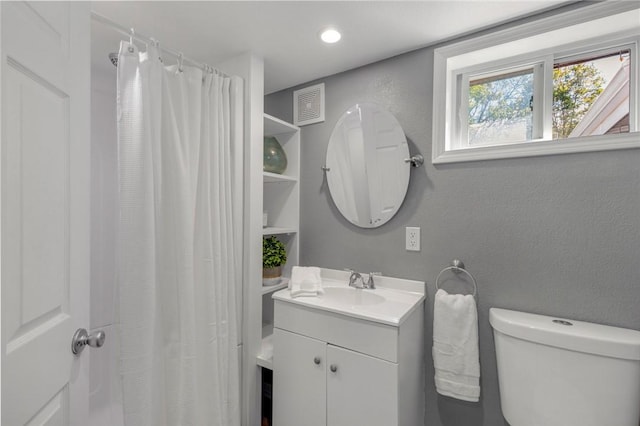 bathroom with curtained shower, recessed lighting, a textured wall, toilet, and vanity