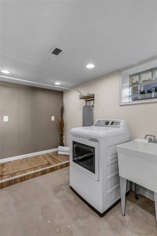 clothes washing area featuring laundry area, a sink, and visible vents