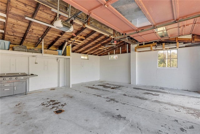 garage featuring concrete block wall and a garage door opener