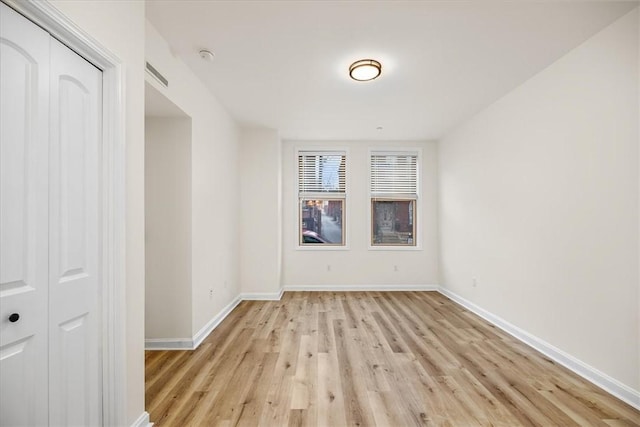 spare room with light wood-type flooring and baseboards