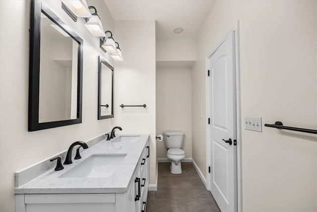 full bathroom featuring baseboards, a sink, toilet, and double vanity