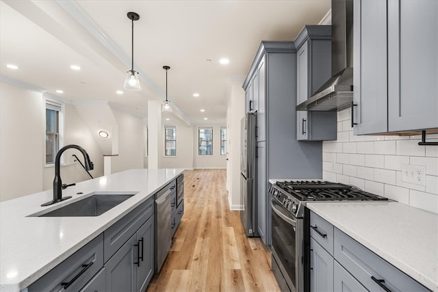 kitchen featuring wall chimney exhaust hood, appliances with stainless steel finishes, gray cabinets, and a sink