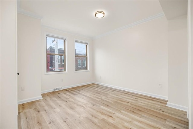 unfurnished room with ornamental molding, baseboards, visible vents, and light wood finished floors