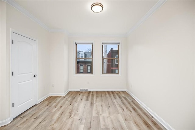 unfurnished room featuring baseboards, light wood-type flooring, and crown molding