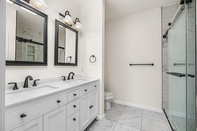 bathroom featuring marble finish floor, a shower stall, and a sink