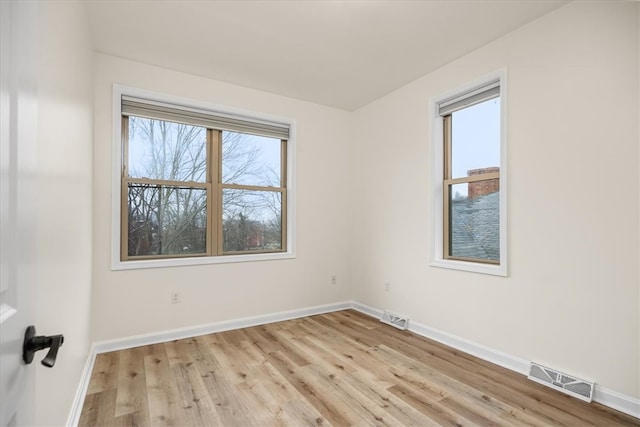 spare room featuring visible vents, plenty of natural light, and baseboards