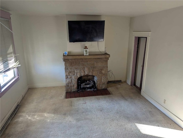 unfurnished living room with baseboards, carpet flooring, and a stone fireplace