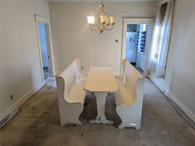 carpeted dining space with baseboards, visible vents, and a notable chandelier