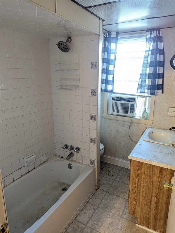 full bathroom with baseboards, toilet, cooling unit, vanity, and washtub / shower combination