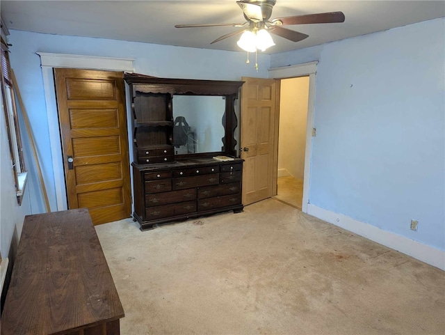 unfurnished living room featuring light carpet, ceiling fan, and baseboards