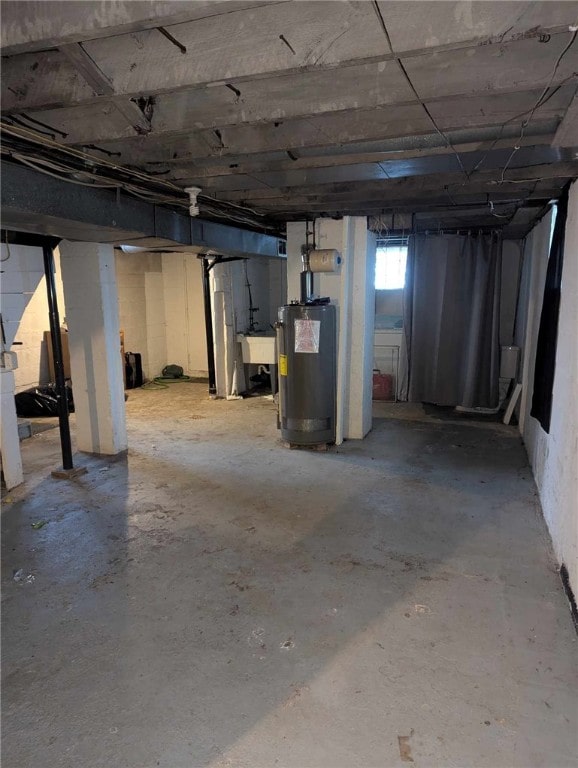 basement featuring water heater and a sink