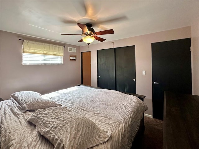 carpeted bedroom with baseboards, visible vents, and a ceiling fan