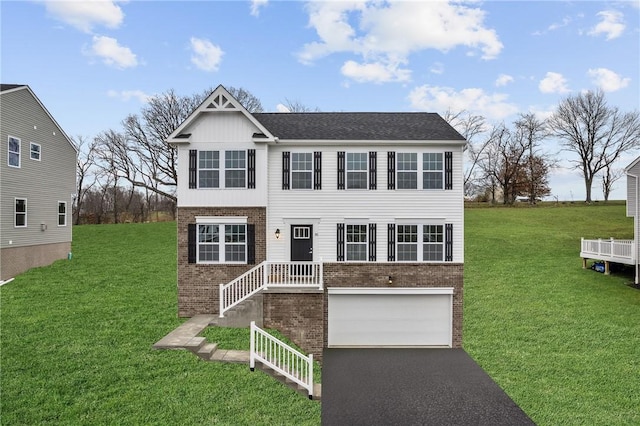 view of front facade with a front lawn, aphalt driveway, and brick siding