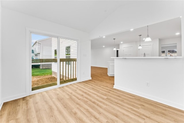 unfurnished living room featuring lofted ceiling, light wood-type flooring, baseboards, and recessed lighting