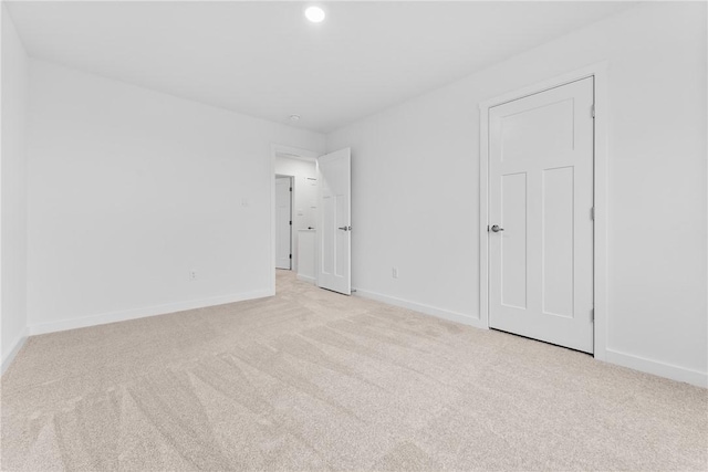 carpeted empty room with baseboards and recessed lighting