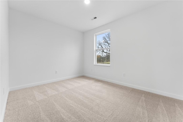 unfurnished room featuring baseboards, visible vents, and light colored carpet