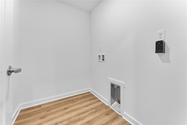 laundry area featuring laundry area, washer hookup, light wood-type flooring, and baseboards