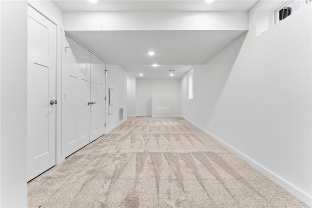 basement with recessed lighting, light colored carpet, visible vents, and baseboards