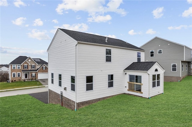 rear view of house featuring a yard and driveway