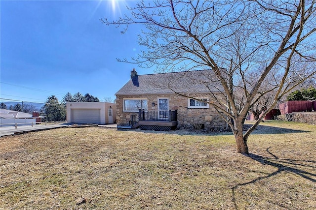 view of front of home with a garage, stone siding, a chimney, and a front yard