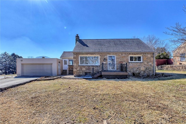 view of front of home featuring a garage, a chimney, and a front lawn