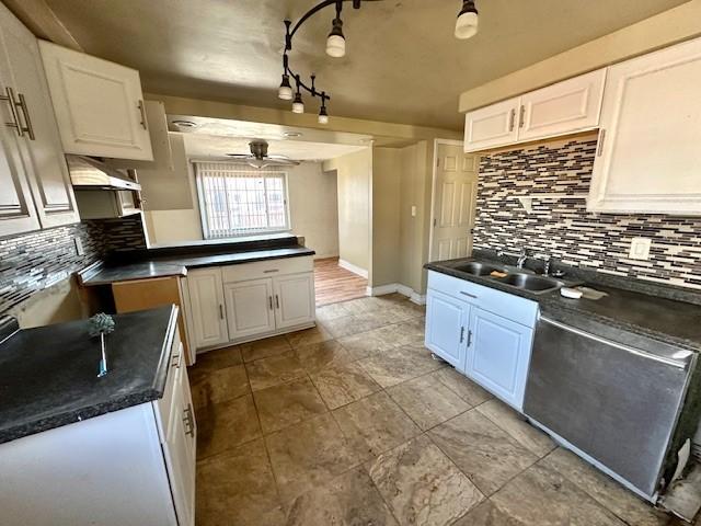 kitchen with dishwasher, dark countertops, a sink, and white cabinets