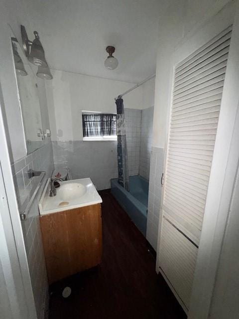 bathroom featuring a shower stall, vanity, and tile walls