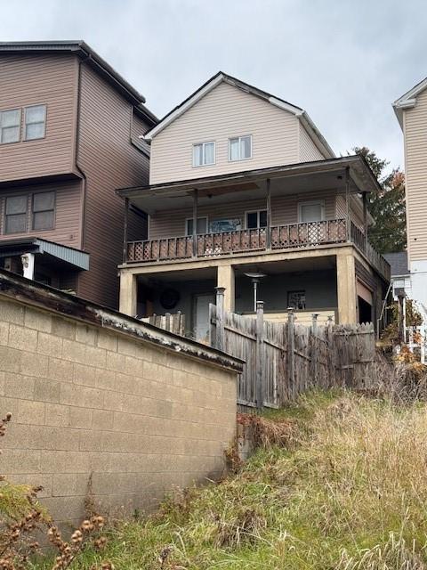 rear view of property featuring fence