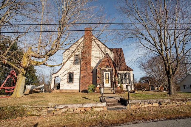 view of front of property with a front yard, fence, and a chimney