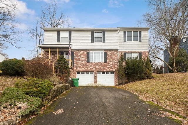 view of front of property with a garage, brick siding, and driveway