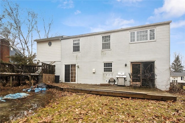 rear view of property with a wooden deck and fence