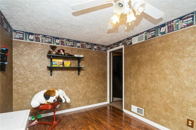 interior space with visible vents, a ceiling fan, a textured ceiling, wood finished floors, and baseboards