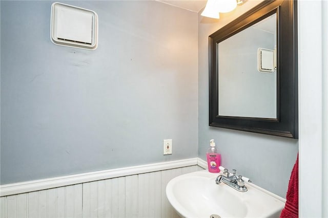 bathroom featuring wainscoting and a sink