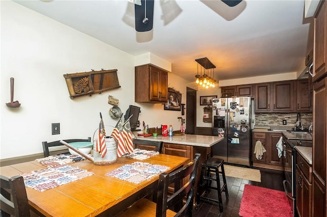 kitchen featuring stainless steel appliances, tasteful backsplash, light countertops, ceiling fan, and dark brown cabinets